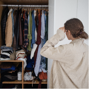 Photo of woman exasperated by messy and crowded closet