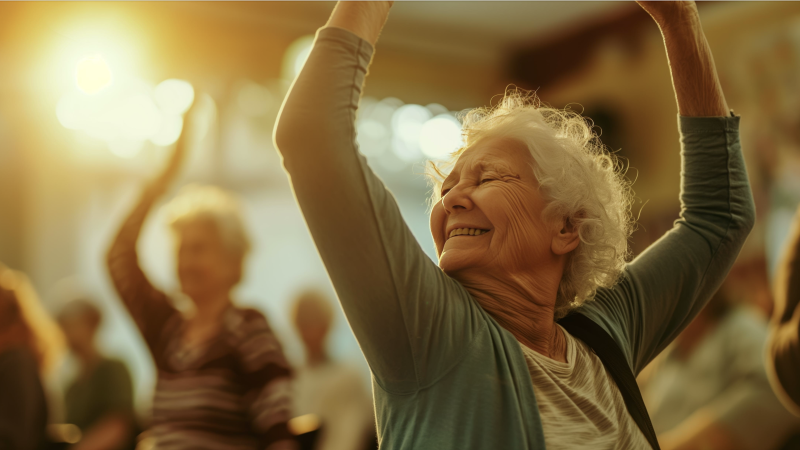 Smiling older woman with arms raised in a yoga pose